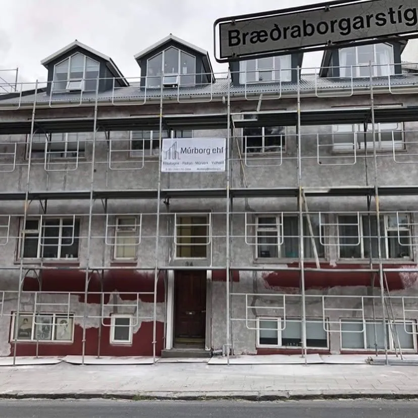 Fjölbýlishús við Bræðraborgarstíg í vinnupöllum með merki Múrborgar